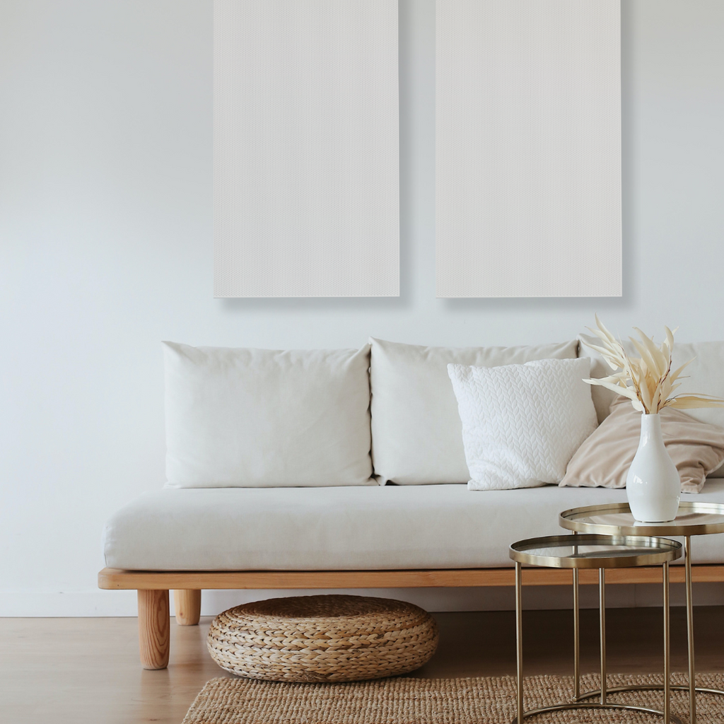 Acoustic wall panels in white from DAMPA hanging over a couch in a living room
